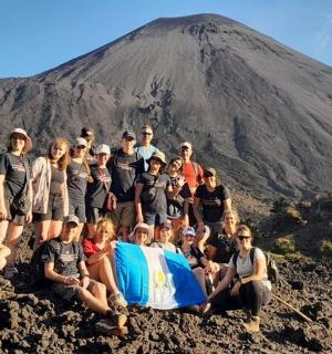 a group of people posing in front of a mountain