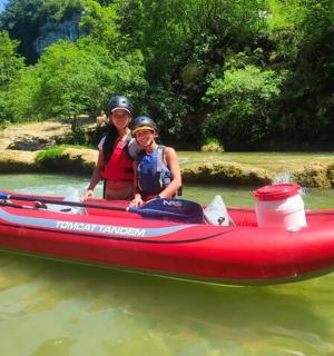 en kvinde og et barn i en rød båd på vandet