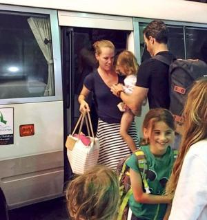 a group of people standing outside of a bus