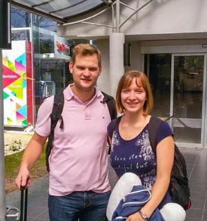 a man and a woman standing in front of a building