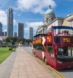 一辆红色双层巴士停在一栋建筑物前