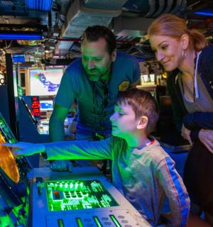 two adults and a child playing a video game