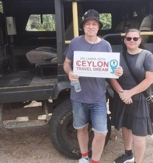a man and woman holding a sign in front of a truck
