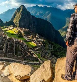 dva lidé stojící na okraji hory a dívající se na starověké ruiny