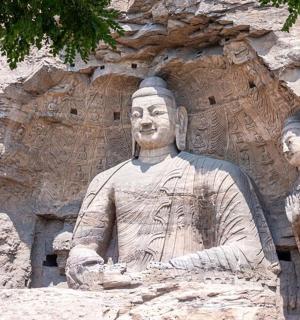 a statue of a man and woman in front of a mountain