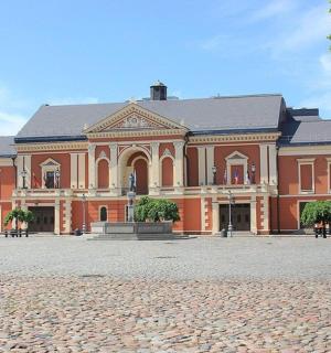 一座大型砖砌建筑，前面有一座雕像