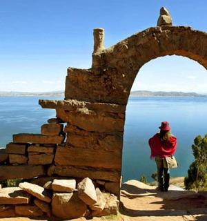 osoba jedoucí na kole kamenným obloukem