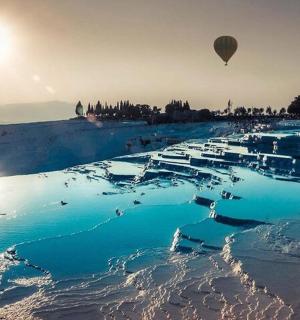 a hot air balloon flying over a body of water