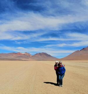 two people are standing in the middle of the desert