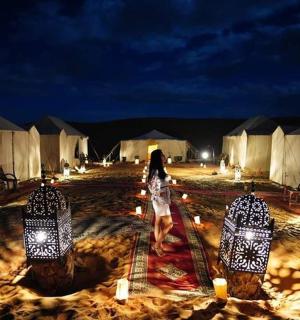 a woman is walking through a group of tents at night
