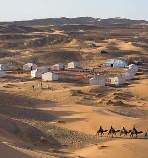 a group of people riding camels in the desert