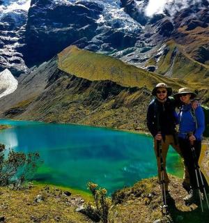 dva lidé stojící na vrcholu hory s jezerem