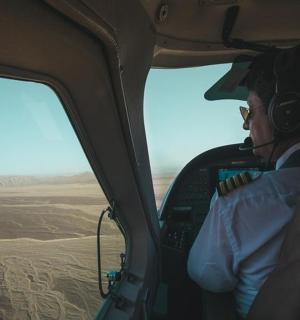 一名男子坐在直升机驾驶舱内