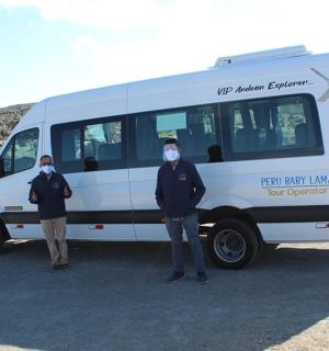 三个戴着口罩的人站在一辆货车前