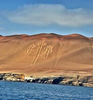 a mountain with writing on it next to a body of water