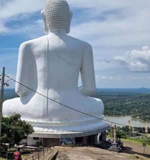 a large white statue sitting on top of a hill