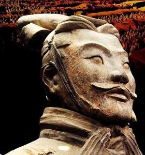 a statue of a face with a crowd behind it