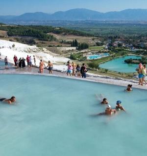 Skupina lidí plave v modré laguně
