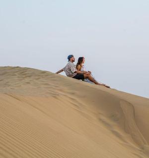 两个人坐在沙丘顶上