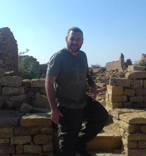 一名男子站在砖墙前