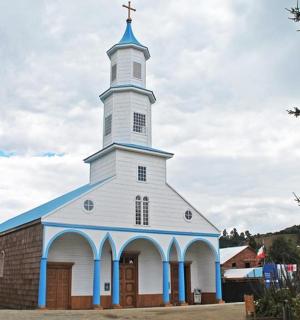 一座白色和蓝色的教堂,顶部有十字架