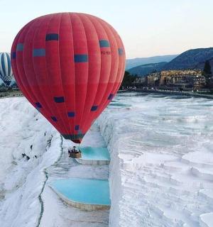 a hot air balloon flying over a frozen river