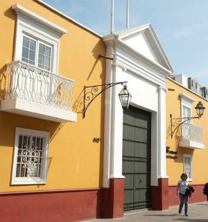 a group of people walking past a yellow building