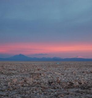 a view of a desert with mountains in the distance