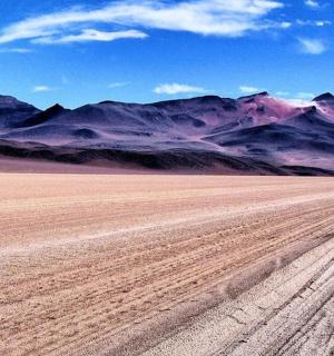 an empty desert with mountains in the background