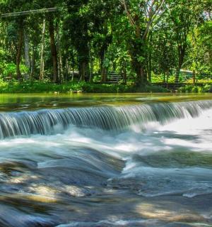 a waterfall in a river with trees in the background
