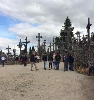 a group of people walking in front of crosses