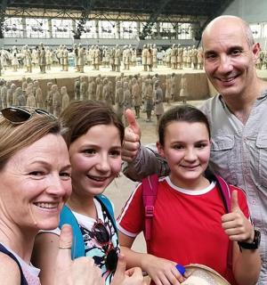 a family posing for a picture in front of a statue