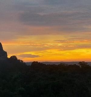 a sunset with a view of a rock formation
