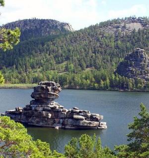 a stack of rocks in the middle of a lake