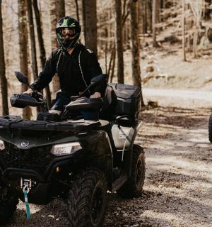 muž na čtyřkolce na nezpevněné cestě