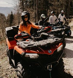 skupina lidí jedoucích na čtyřkolkách po nezpevněné cestě