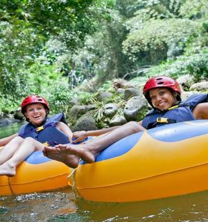 two children are sitting on an orange raft in the water
