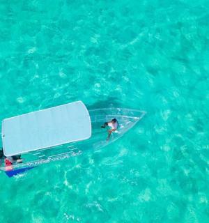 一名男子在蓝色海水中的船上