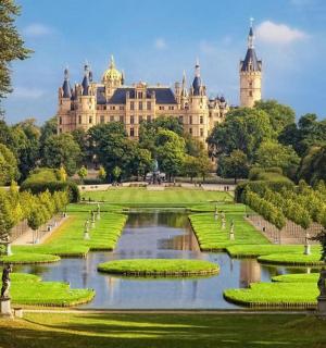 a garden with a large building in the background