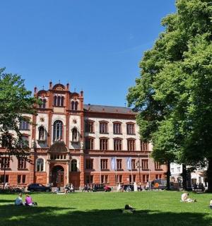 people sitting in the grass in front of a building