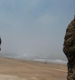 pohled na pláž skrz skalní okno