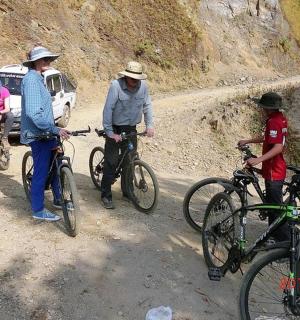 一群人骑着自行车在土路上行驶