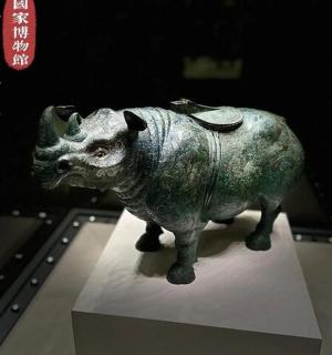 a statue of a bull on a stand in a museum