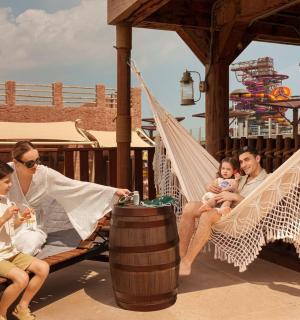 กลุ่มคนนั่งอยู่บนเปลญวนบนเครื่องเล่น