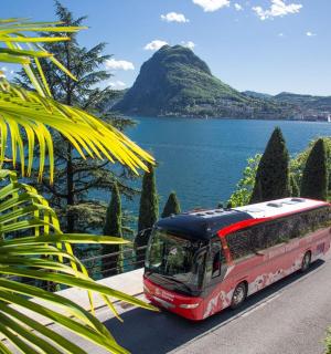 un autobús que circula per una carretera al costat de l'aigua