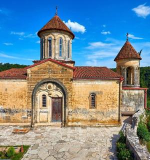 an old church with two towers on top of a hill
