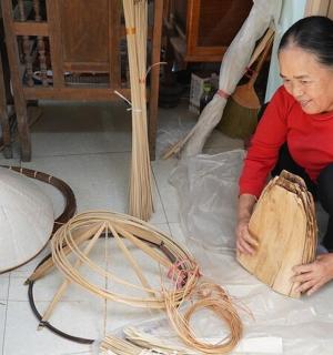 一位女士坐在地板上，手里拿着一块木头