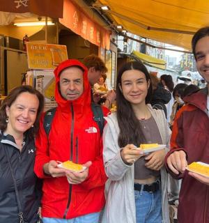 一群人站在市场里，手里拿着食物