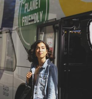 a woman standing in front of a bus