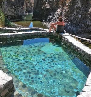 一位女士坐在一个大水池旁边